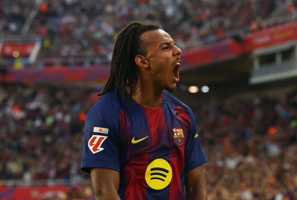 Vibrant image of a passionate football player in FC Barcelona kit celebrating on the field during a match, showcasing sports enthusiasm and team spirit.