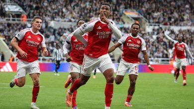 Energetic Arsenal football players celebrating a goal during a match on the field.