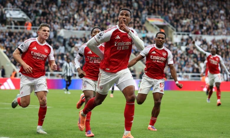 Energetic Arsenal football players celebrating a goal during a match on the field.