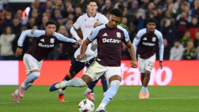 Vibrant soccer match featuring Aston Villa players in maroon jerseys competing on the field with a lively crowd background.