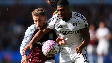 Intense football match featuring players from Aston Villa and Fulham competing fiercely for the ball during a daytime game. Action-packed moment showcasing athleticism and sportsmanship.
