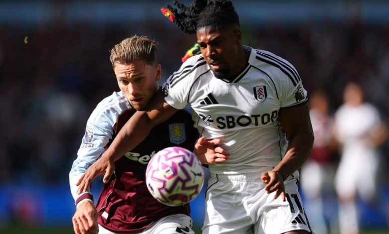 Intense football match featuring players from Aston Villa and Fulham competing fiercely for the ball during a daytime game. Action-packed moment showcasing athleticism and sportsmanship.