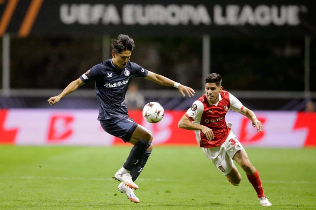 Dynamic soccer match between two teams during UEFA Europa League, players competing for ball possession on the field.
