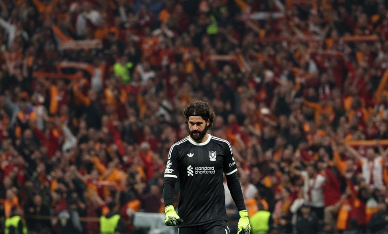 Excited soccer goalkeeper in black uniform with crowd in stadium background during match at ZareSport.et.