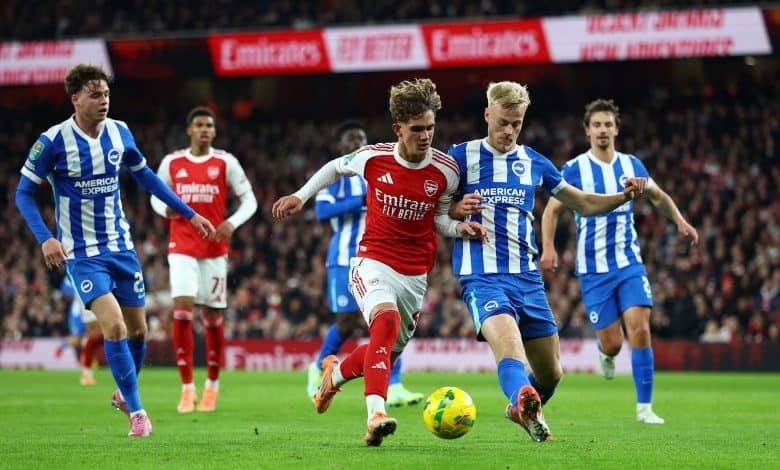 Bright soccer match featuring players from Arsenal and Brighton & Hove Albion competing for possession of the ball during a professional English Premier League game.