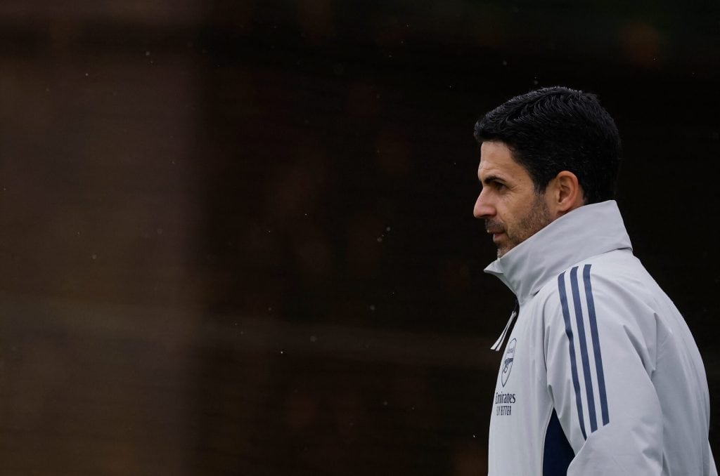 Focused male athlete in white sports jacket with blue stripes, standing outdoors on a cloudy day, ready for training or sports event, emphasizing athletic wear and sports motivation.