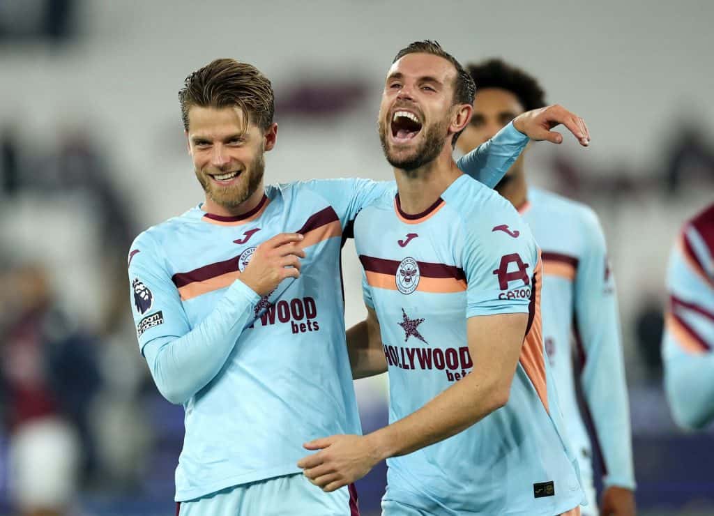 Vibrant football players celebrating a goal in West Ham United jerseys during a match.