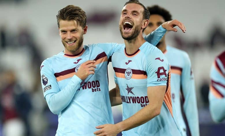 Vibrant football players celebrating a goal in West Ham United jerseys during a match.