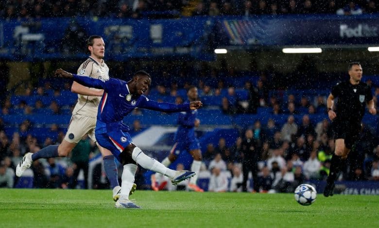 Rain-soaked soccer match featuring players from Chelsea FC and opposing team, intense action during a UEFA Champions League game at ZareSport.et.