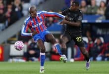 Dynamic soccer match action with two players competing for ball possession on the field.