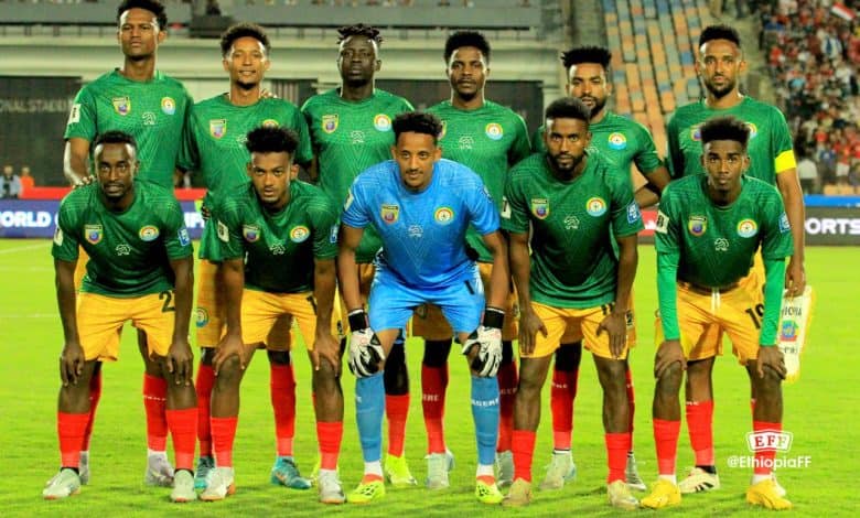 Ethiopia Finish with Pride in World Cup Qualifying Ethiopian national football team in green and yellow kits during a match, team members posed on the field, showcasing team spirit and competitiveness, vibrant stadium background.