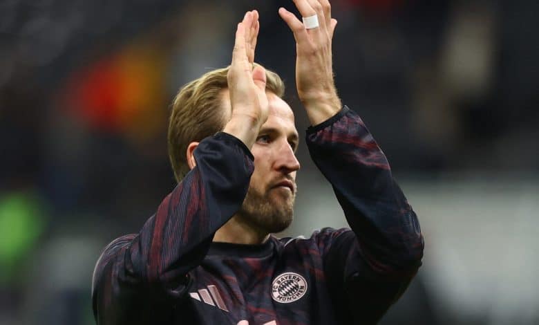 Harry Kane’s Bayern Love Story: Why He Might Never Come Back Energetic football player clapping during match, wearing Bayern Munich jersey, celebrating teamwork and sportsmanship on the field.