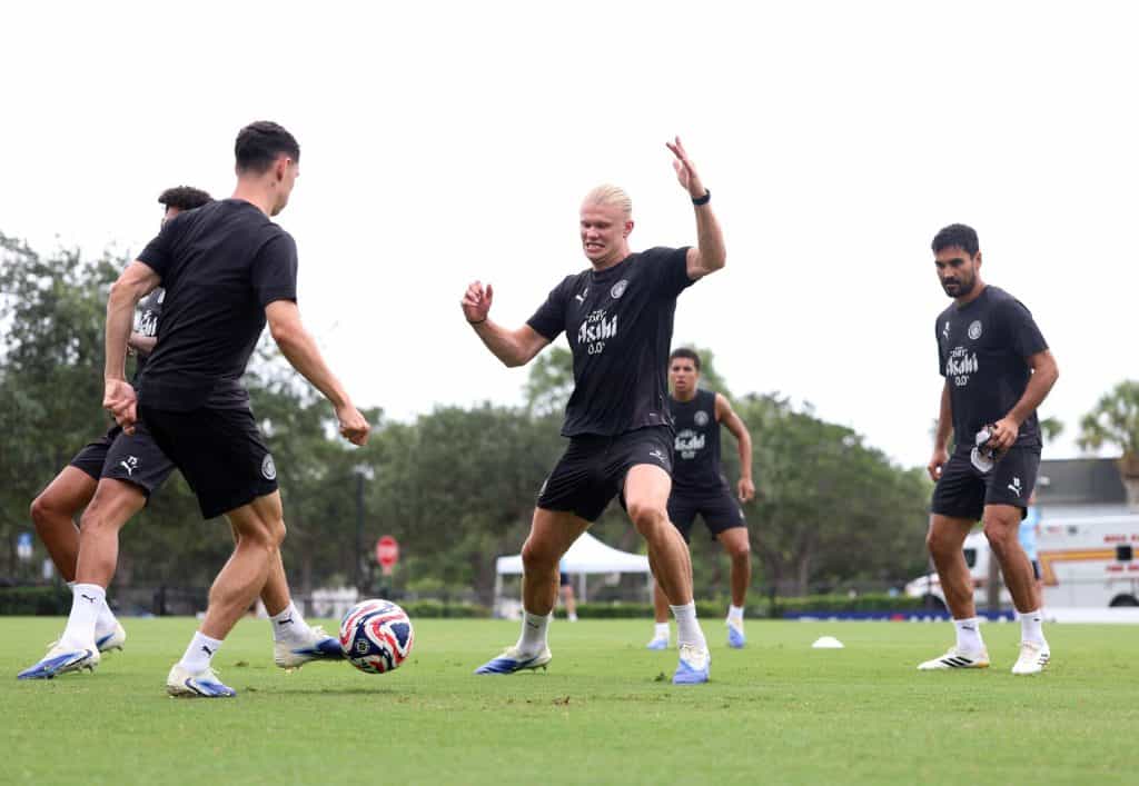 Soccer players during training session on green field, wearing black sports uniforms, vibrant action shot, team practice, athleticism, football skills, sports training, ZareSport.et marketing, athletic apparel, team sport, youth soccer, fitness, outdoor sports, soccer coaching, athletic performance.