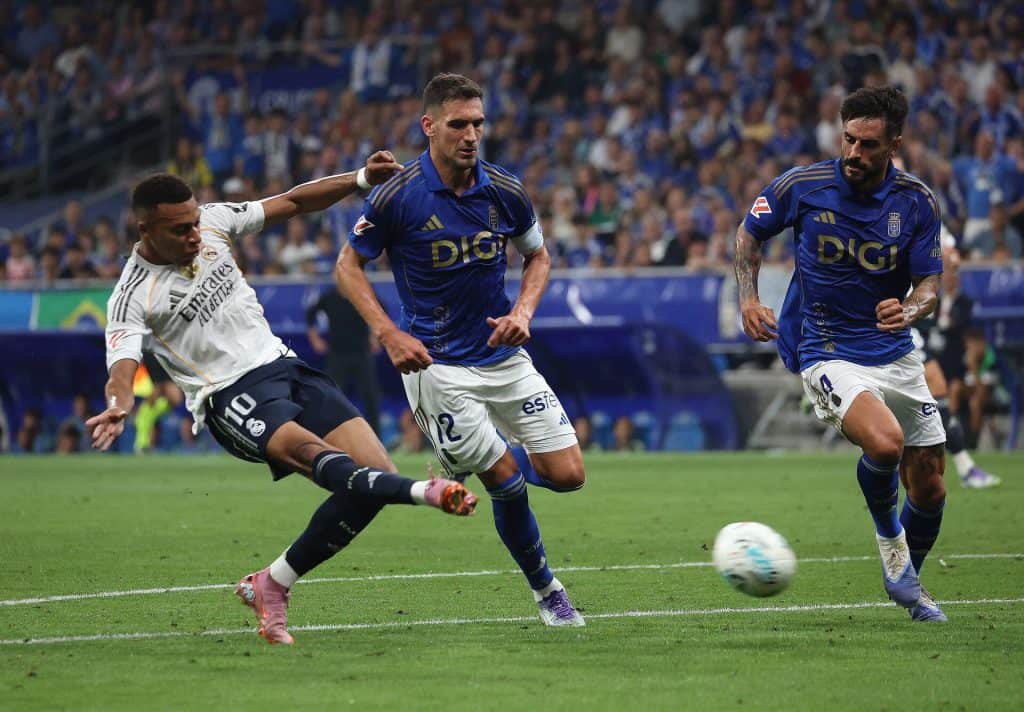 FIFA soccer match with players from Real Madrid and Estudiantes de La Plata competing on the field during a thrilling game.