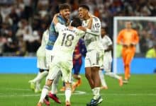 Celebrating football players on the field after scoring a goal during a match, showing team camaraderie and excitement.