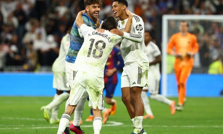 Celebrating football players on the field after scoring a goal during a match, showing team camaraderie and excitement.