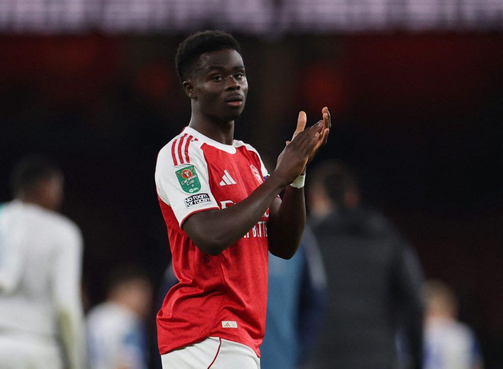 Fast football player celebrating on the field in a red and white jersey, team logo visible, during a match, sports action, athlete in motion, team sports, ZareSport.et focus.