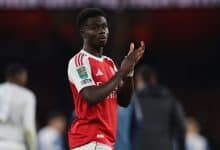 Fast football player celebrating on the field in a red and white jersey, team logo visible, during a match, sports action, athlete in motion, team sports, ZareSport.et focus.