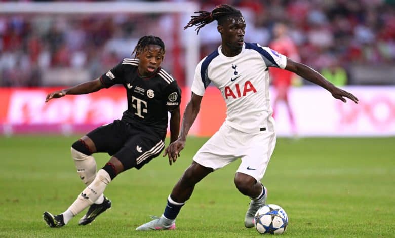 Action-packed soccer match featuring Tottenham Hotspur and Bayern Munich players competing for the ball during an intense stadium game.