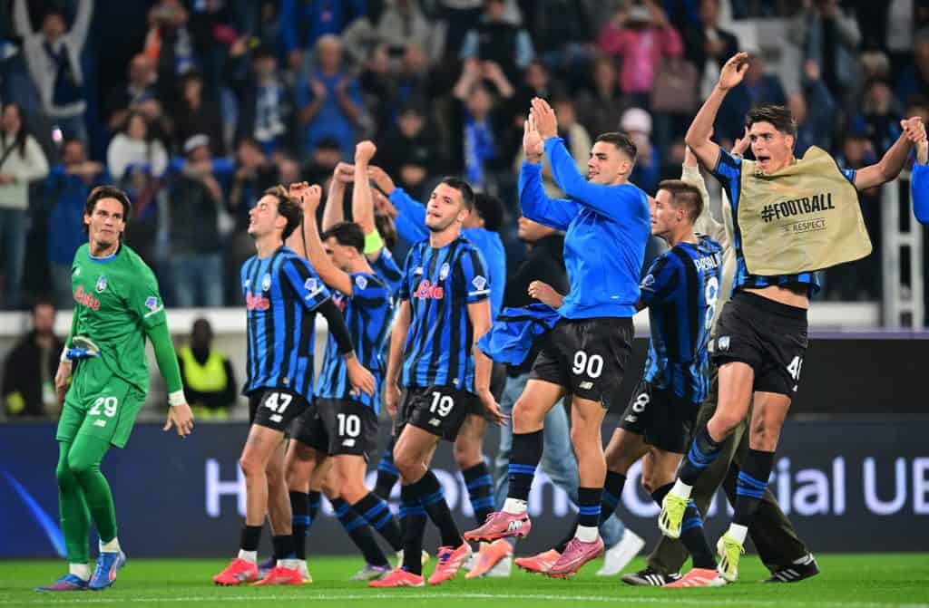 Players celebrating football victory in stadium after match victory.
