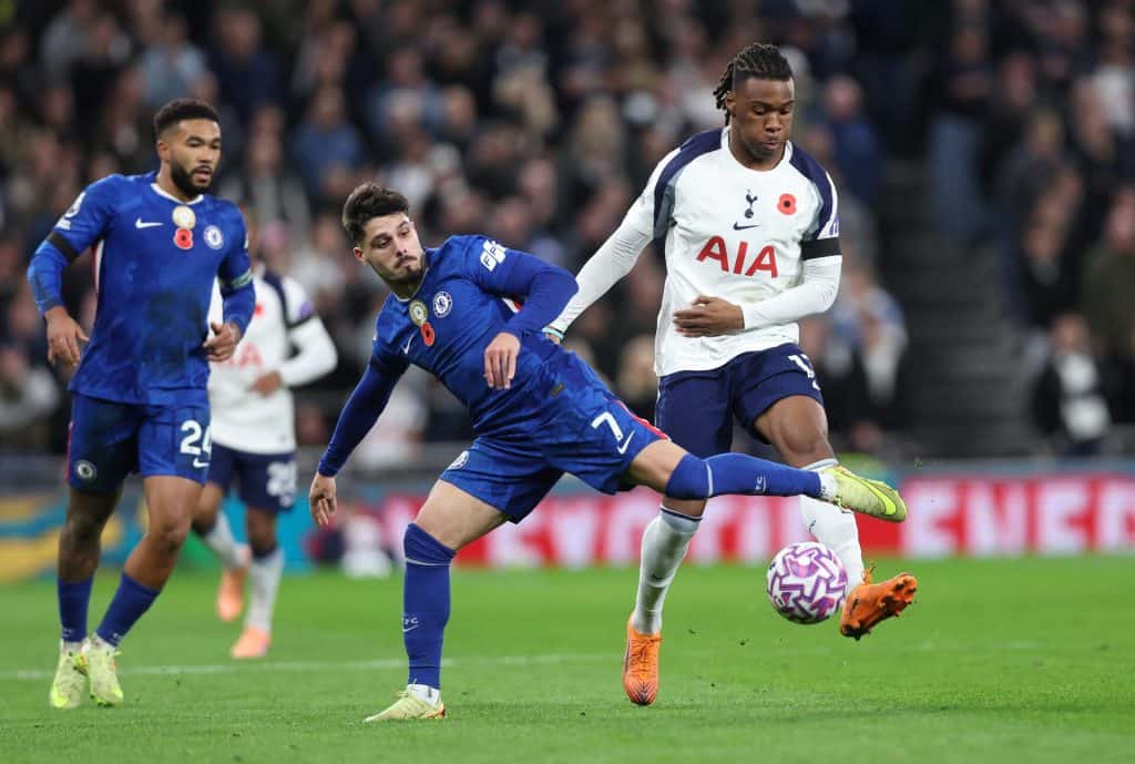 Striker and defenders competing for football ball during a Premier League match between Tottenham Hotspur and Chelsea, with players in action on the field.