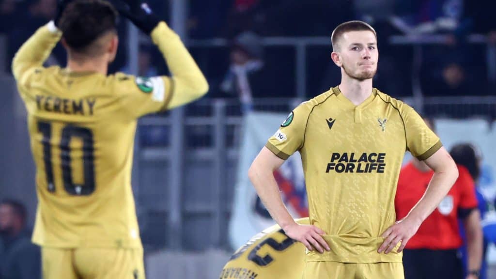 Soccer players wearing yellow uniforms on the field, one looking serious with hands on hips and the other adjusting their jersey, emphasizing sportsmanship and team spirit.