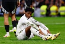Young soccer player sitting on the field with muddy uniform after game injury, showcasing athleticism and teamwork.