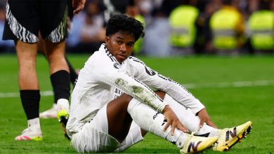 Young soccer player sitting on the field with muddy uniform after game injury, showcasing athleticism and teamwork.