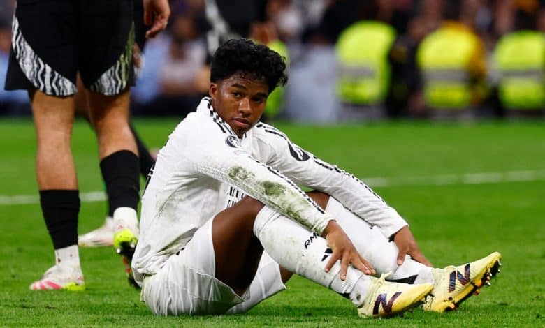 Young soccer player sitting on the field with muddy uniform after game injury, showcasing athleticism and teamwork.