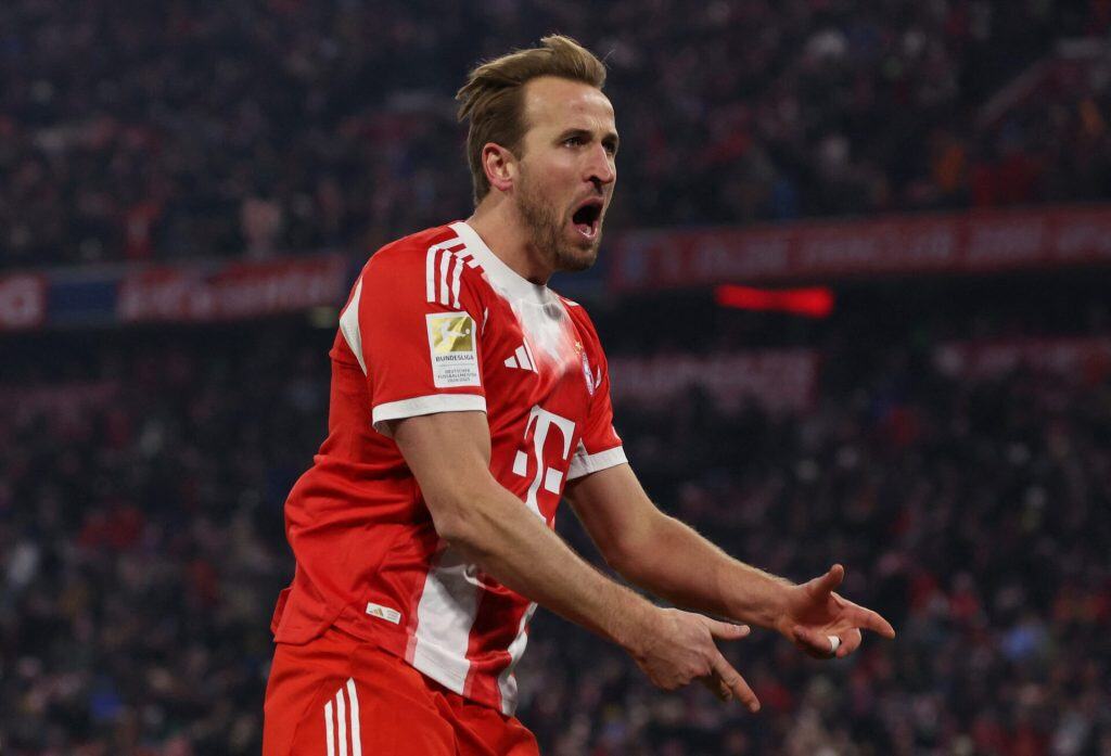 Energetic soccer player celebrating on the field in Bayern Munich uniform, showcasing passion and team spirit during a match.