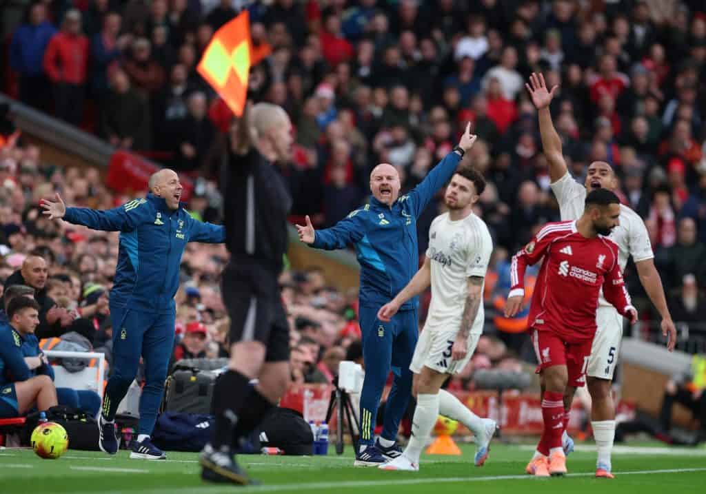 Vibrant soccer match scene with passionate players and coaches on the sideline during a competitive game, capturing intense moments and team emotions in a stadium filled with cheering spectators.