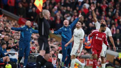 Vibrant soccer match scene with passionate players and coaches on the sideline during a competitive game, capturing intense moments and team emotions in a stadium filled with cheering spectators.