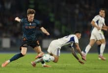 Dynamic soccer players competing for the ball during a match, showcasing competitive sports action and athletic skill.