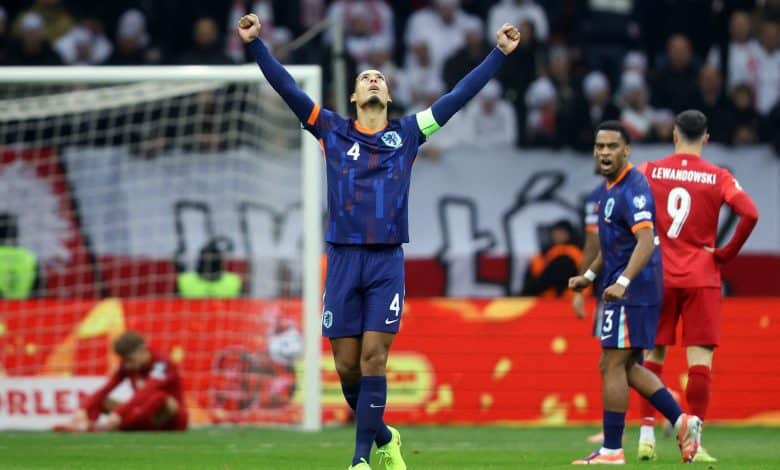 Ethiopian soccer player celebrating a goal on the field during a match, wearing a blue jersey with the number 4, with teammates and opponents visible in the background.
