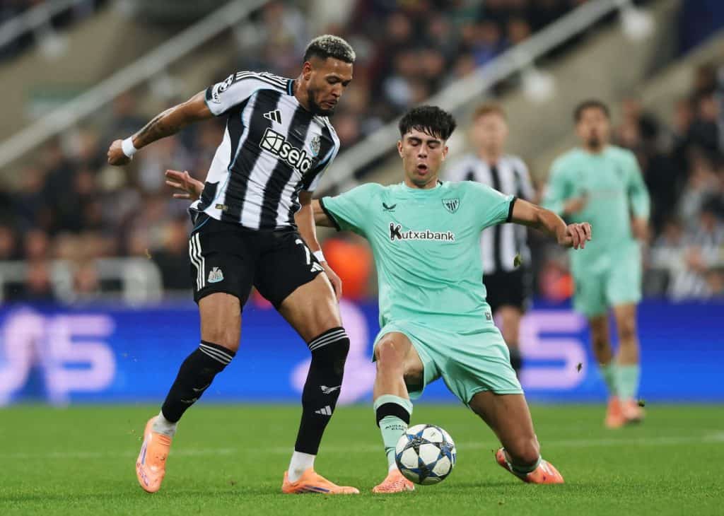 Men's soccer match action featuring players from Newcastle United and Atlético Madrid competing for ball control.