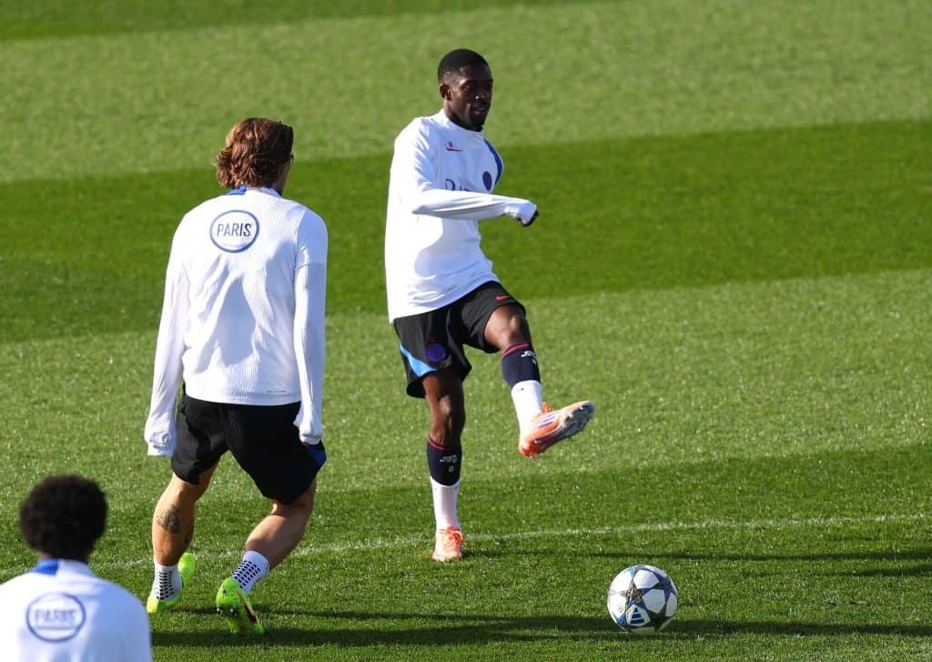 Professional soccer players practicing on the field during training session.
