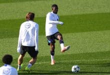 Professional soccer players practicing on the field during training session.