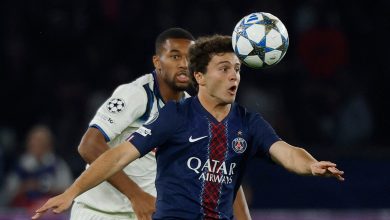 An intense soccer match featuring Paris Saint-Germain’s Kylian Mbappé heading the ball past an opponent during a UEFA Champions League game. Action-packed moment showcasing professional football skills.