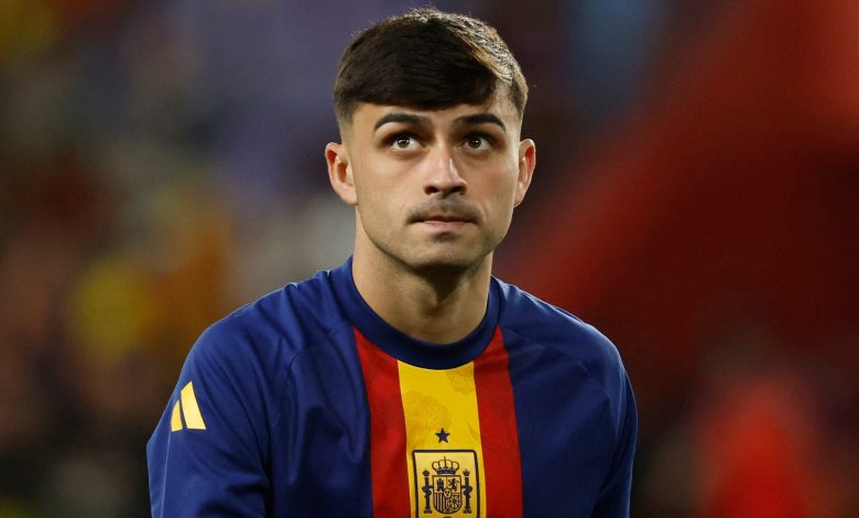 Young male soccer player in Spain national team jersey, focusing during match.
