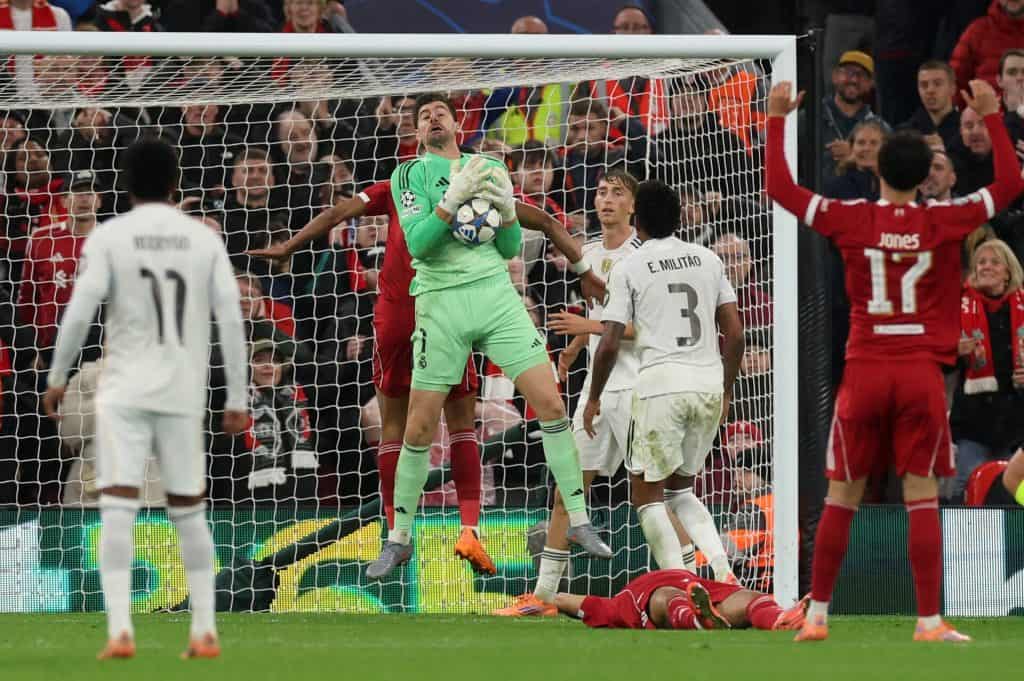 Stunning soccer match moment with goalkeeper diving to catch the ball, surrounded by joyful players and passionate fans, showcasing intense action and excitement of football.