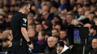 Flag of the referee with the laptop screen showing the match in the background.