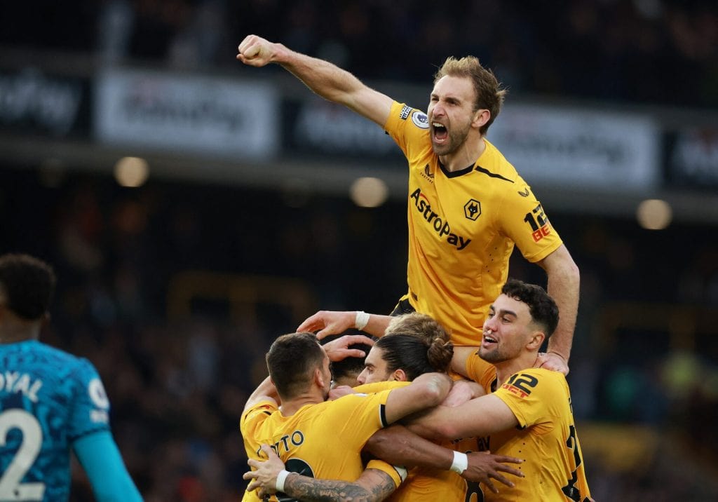 Celebrating soccer players in yellow jerseys high-fiving during a match, expressing victory and team spirit, capturing the excitement of live sports events.