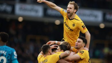 Celebrating soccer players in yellow jerseys high-fiving during a match, expressing victory and team spirit, capturing the excitement of live sports events.