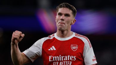 Professional Arsenal football player celebrating with fist pump during match, wearing red and white jersey, dynamic sports action, stadium background, sportswear, athletes, football, soccer, team sports, ZareSport.et relevancy.