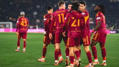 Soccer players in maroon and yellow uniforms celebrating strategy and teamwork.