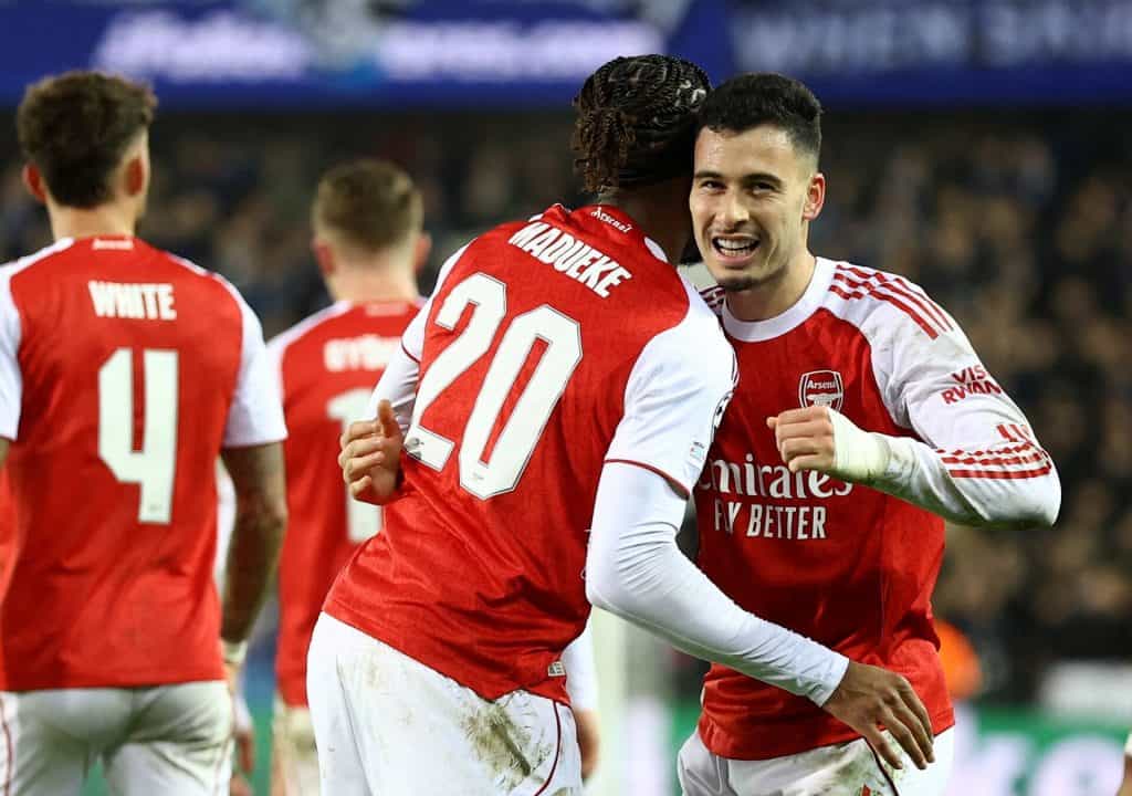 Close-up of Arsenal soccer players celebrating a goal during a match, showcasing teamwork and excitement on the field.