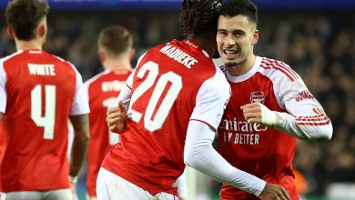 Close-up of Arsenal soccer players celebrating a goal during a match, showcasing teamwork and excitement on the field.