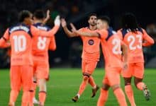 High-energy sports moment capturing football players celebrating on the field during a match.