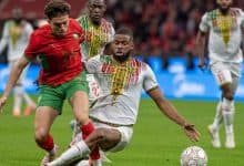 Football players competing on the field, showcasing athleticism and teamwork during a live soccer game.