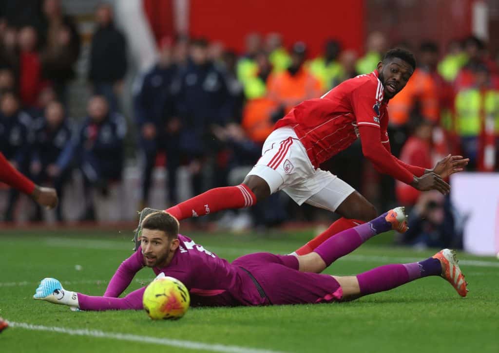 Dynamic soccer match with players competing intensely for the ball on the field.